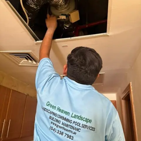 Technician at an outdoor condenser unit — AC Maintenance project photo, Dubai