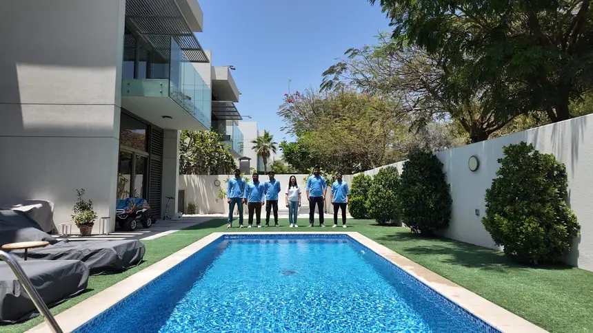 Green Heaven Landscape crew beside a completed villa swimming pool, lawn and garden in Dubai