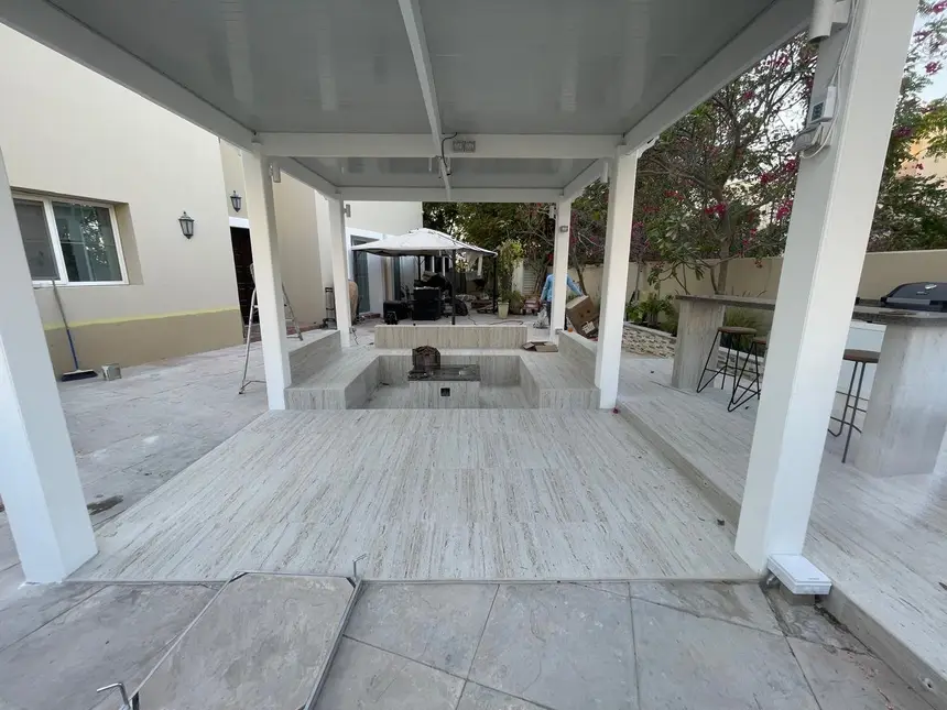 Sunken, tiled lounge with a stone-clad fire feature — Hardscape and Tile Work project photo, Dubai