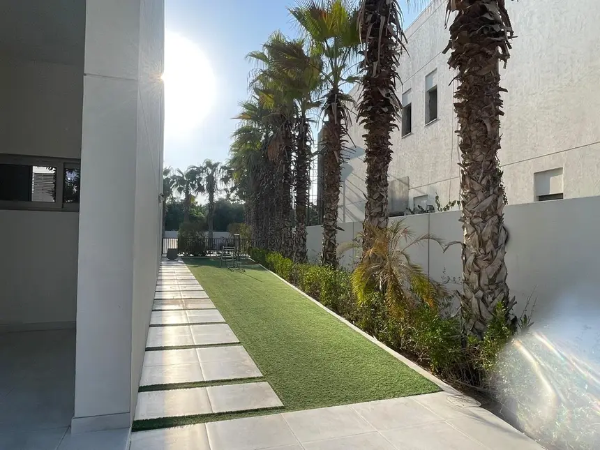 Side yard in artificial turf with stepping stones and palms — Courtyard Pool & Deck Retreat, Green Heaven Landscape project
