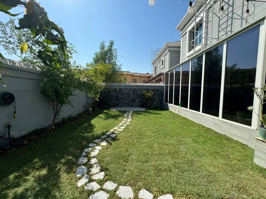Stone path along a white-walled side yard — Estate-Style Entrance & Side Gardens, Green Heaven Landscape project