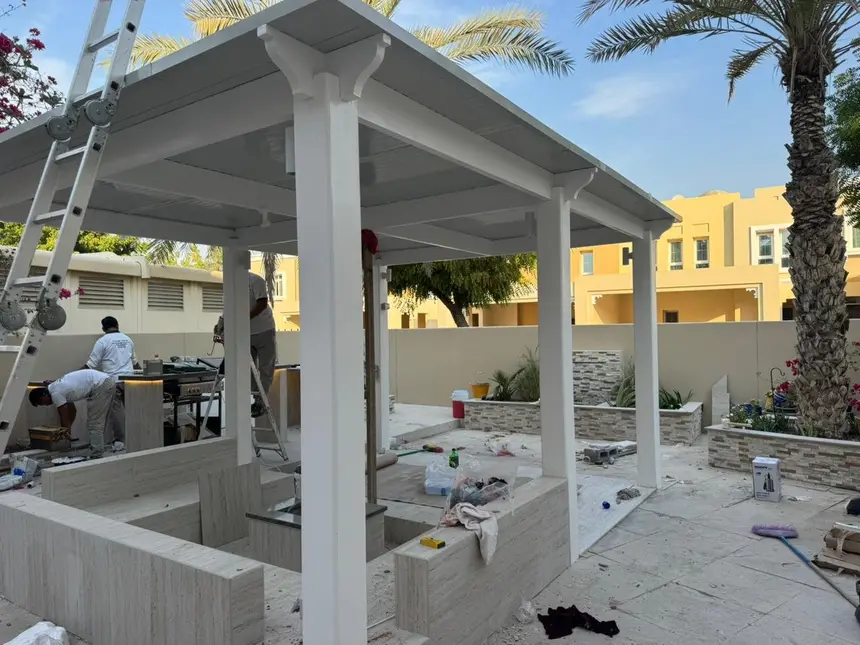 Pergola frame goes up — steelwork fixed to the patio slab — Pergola Majlis & Outdoor Kitchen, Green Heaven Landscape project