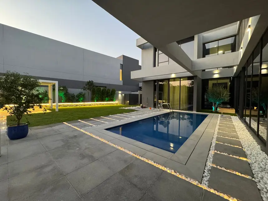 Pool and patio lit for evening entertaining — Private Villa Pool Transformation, Green Heaven Landscape project photo